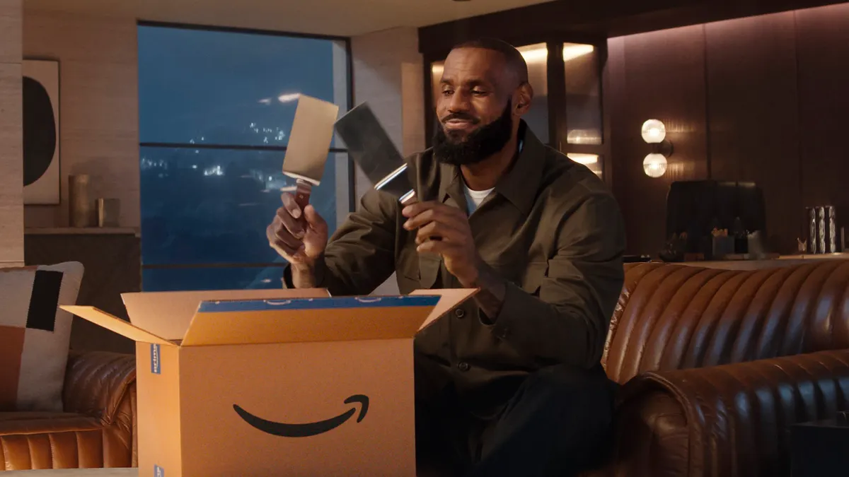 LeBron James holds spatulas that have come out of an Amazon box.