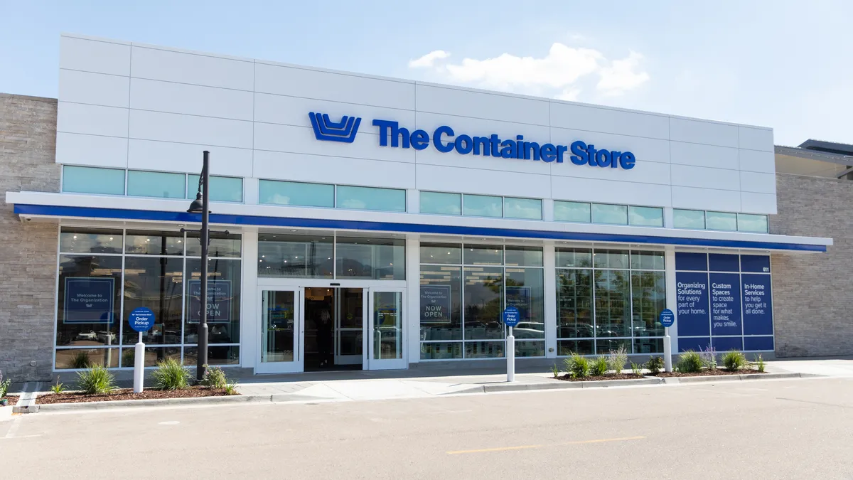 A white storefront with a blue Container Store logo on it.