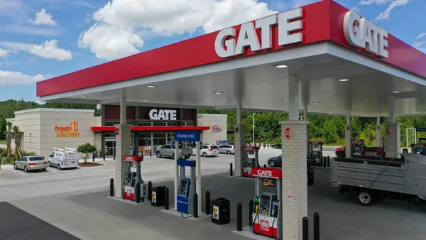 A photo of the exterior of a gas station and convenience store. Signs on the canopy and store says "Gate" and a second sign on the store says "Fresh Kitchen."