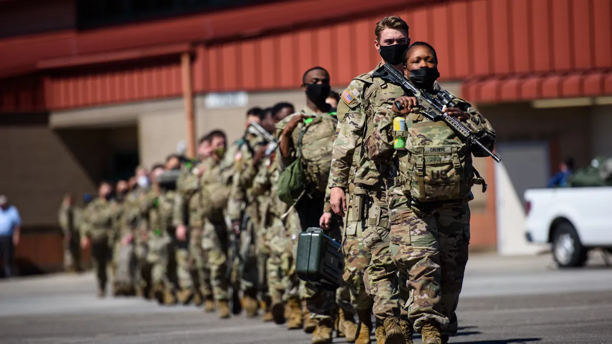 U.S. army soldiers shown marching with packs on before deployment to Germany in 2022