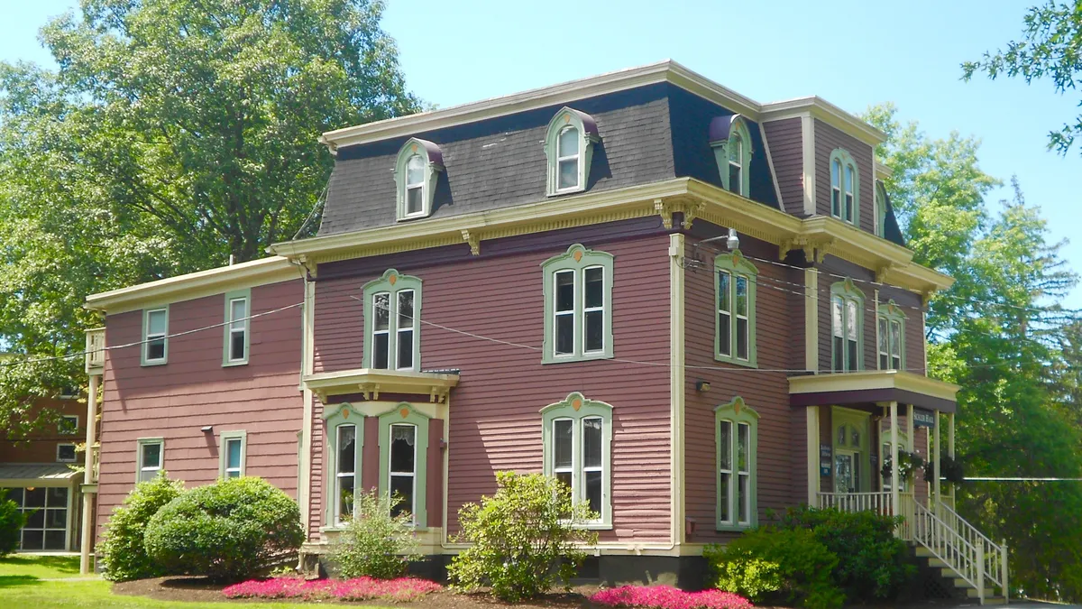 A blush-colored, stately old house that has been repurposed into an academic building