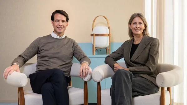 Jonatan Janmark and Helena Helmersson sit in arm chairs for a professional photo.