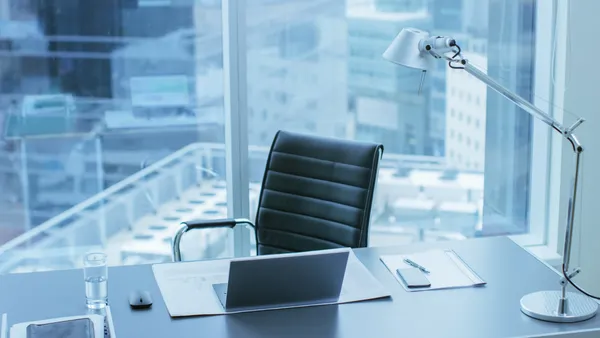 High view of an empty desk along a window.