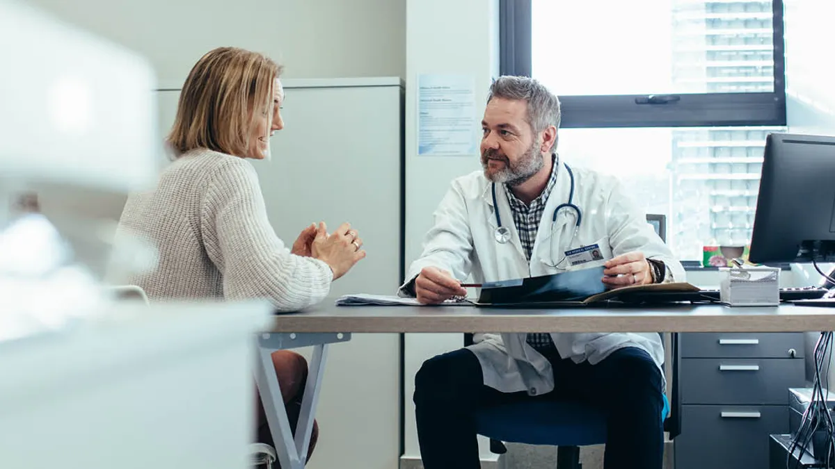 A patient and doctor talking at a table
