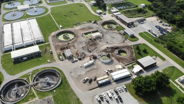 An aerial view of an industrial complex surrounded by foliage.