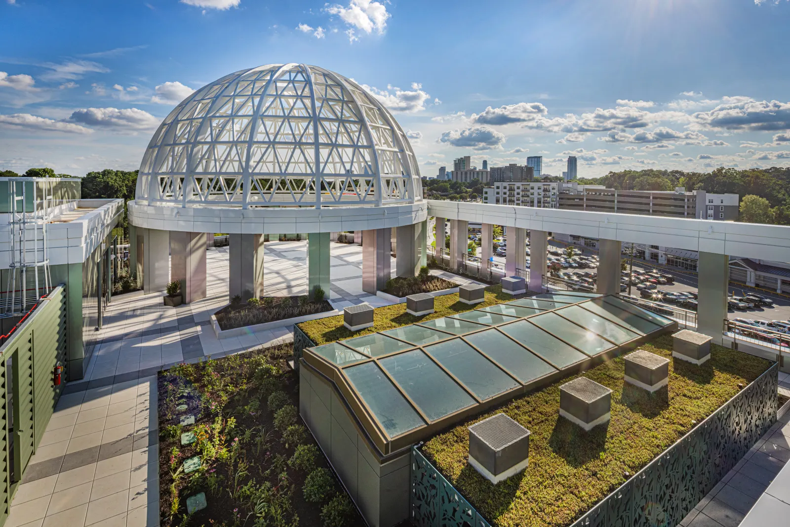 An image of an open air rooftop with a small circular column and open space with greenery.