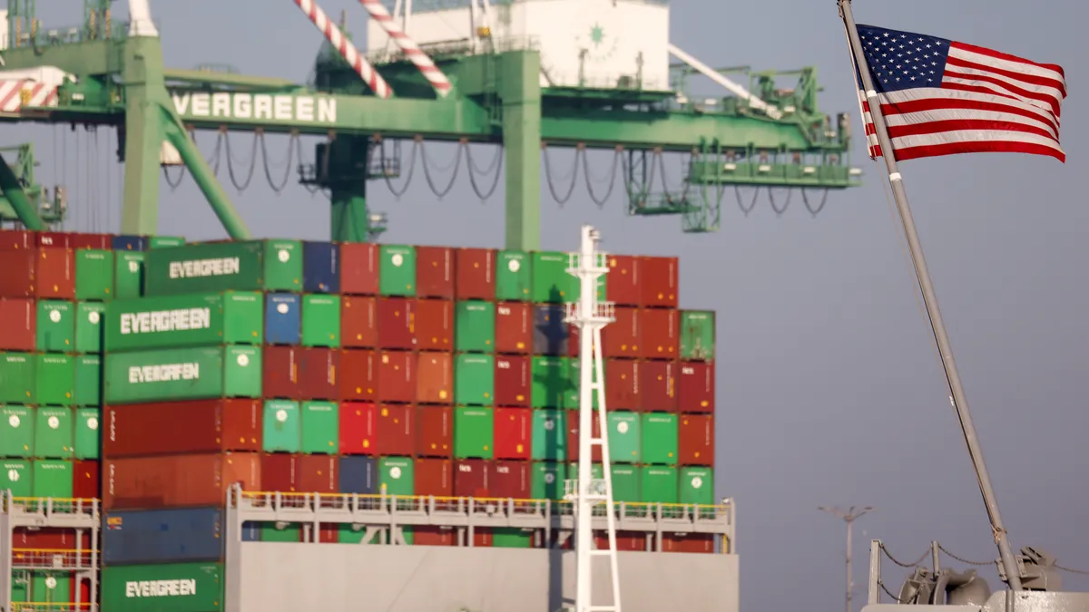 An American flag flies near a container ship at the Port of Los Angeles on November 30, 2021.