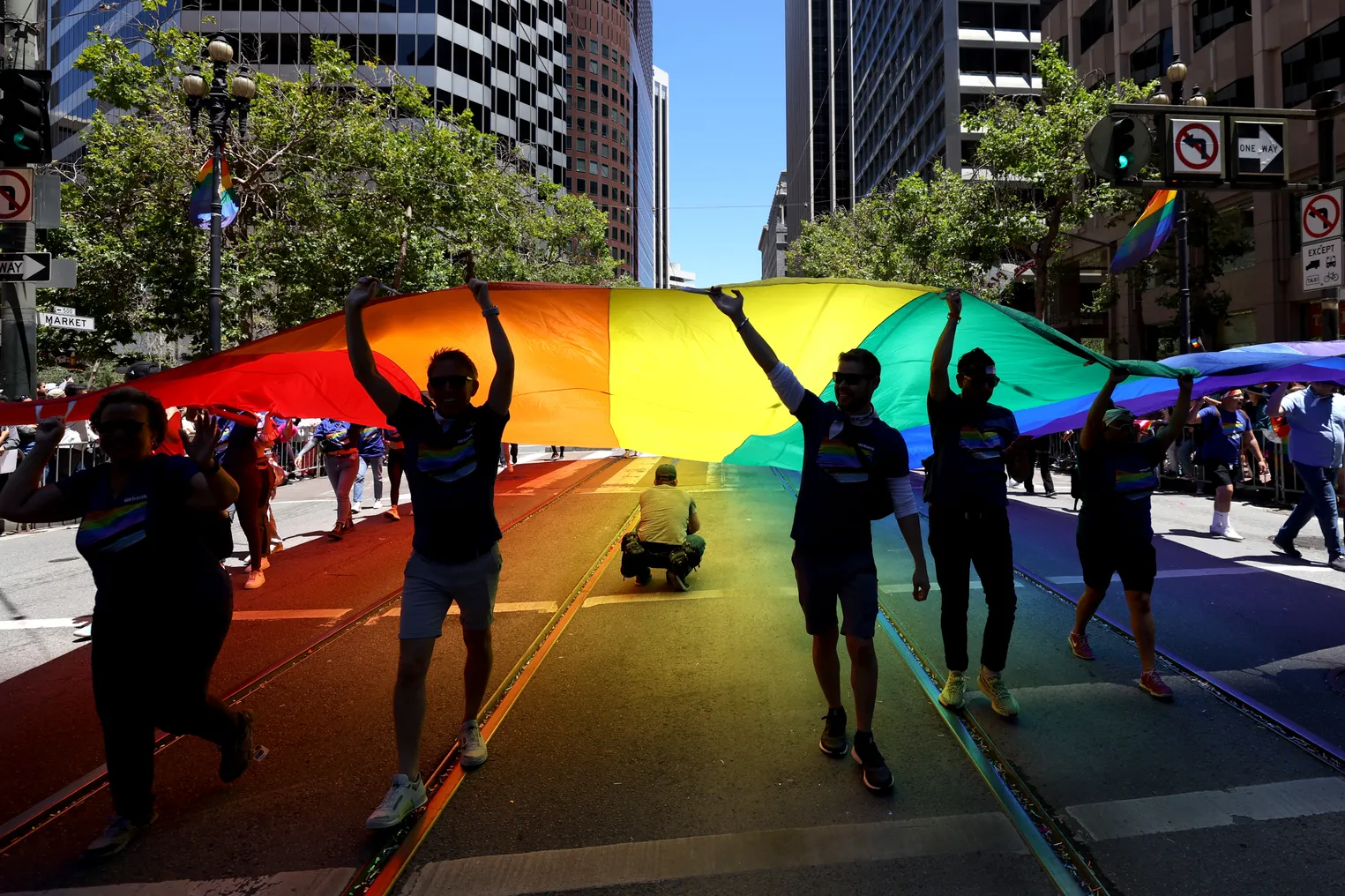 Light through the Pride flag turns the street many colors.