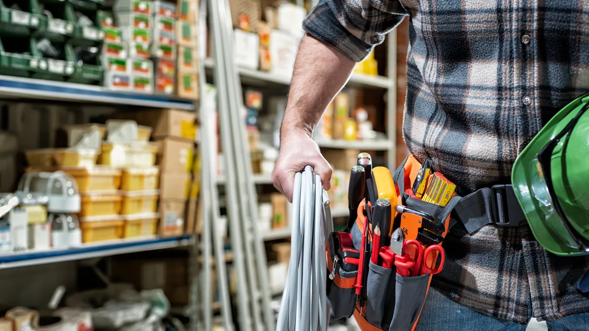 A construction worker gathers materials in a supply store.