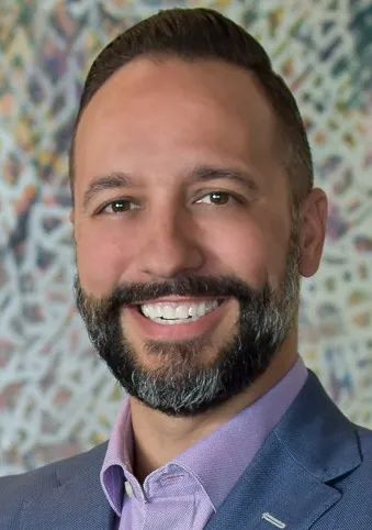 Man with beard smiling.