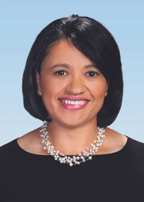 Woman with shoulder length black hair and a black top smiles.