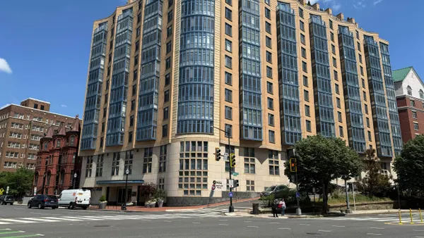 High-rise brick and tan apartment building on a street corner