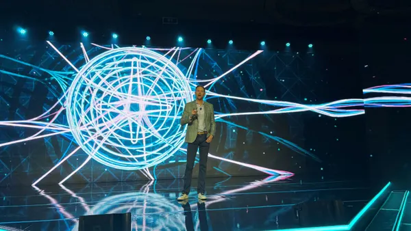 man on stage in front of a screen