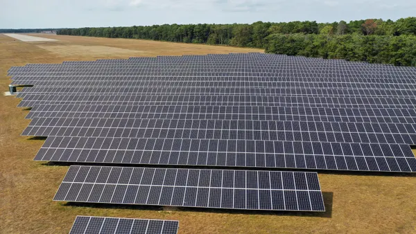 An array of solar panels in a field.