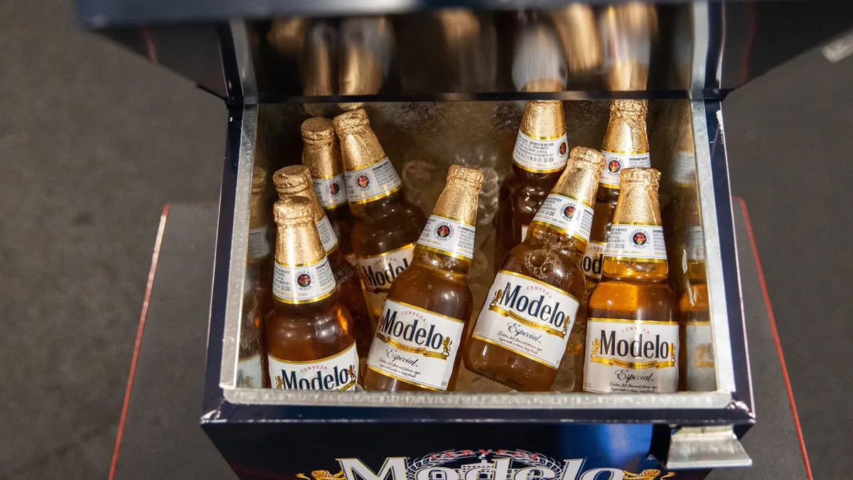A photo of bottles of beer in a cooler. The bottles say Modelo.