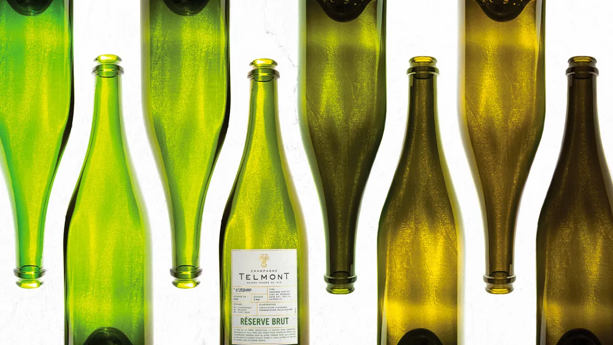 Eight wine bottles in various shades of green and amber with Champagne Telmont branding on the label.