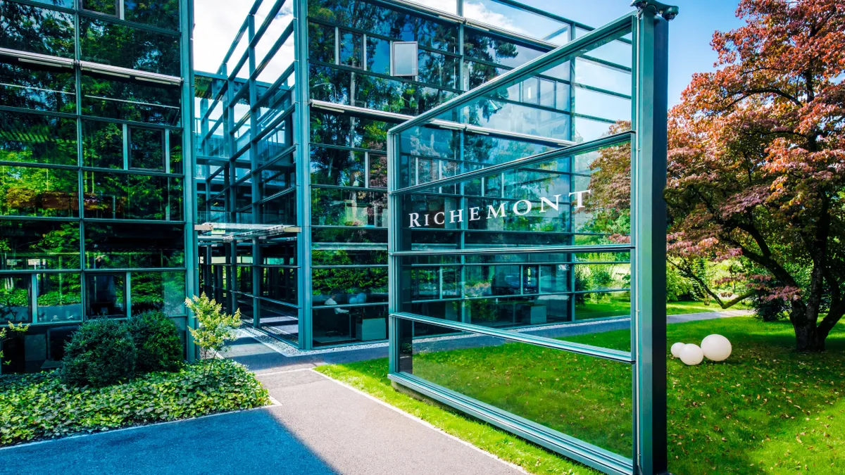 the front entrance of the Rochemonth headquarters in Geneva, Switzerland features a green lawn and glass signage.