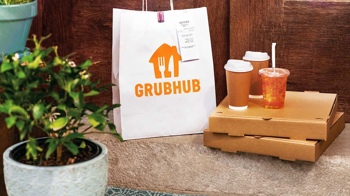 A photo of some cups and boxes along with a bag with Grubhub on the side.