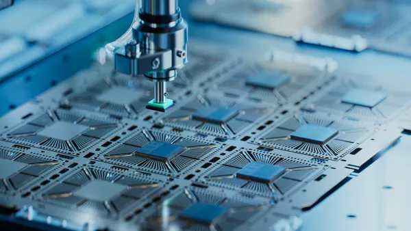 Close-up of silicon die being extracted from semiconductor wafer and attached to the substrate by a pick and place machine.