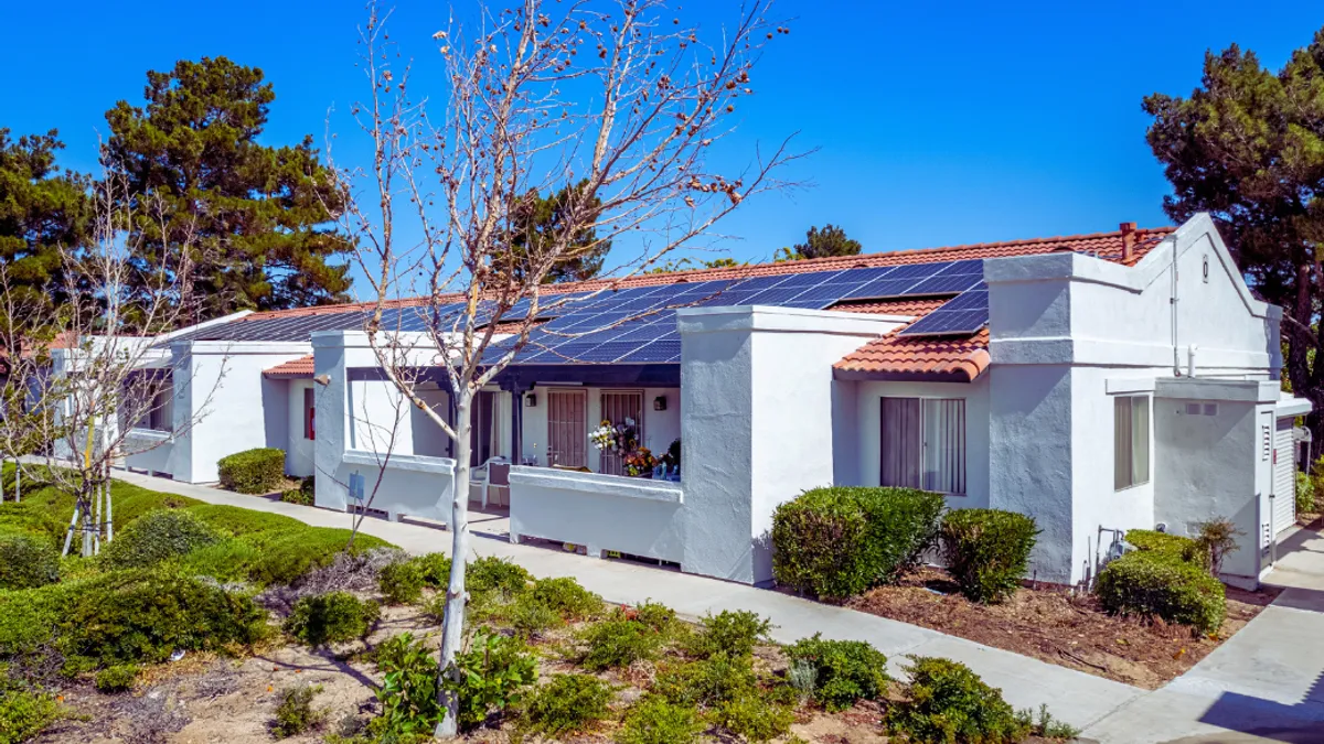 White house with solar panels on the roof.