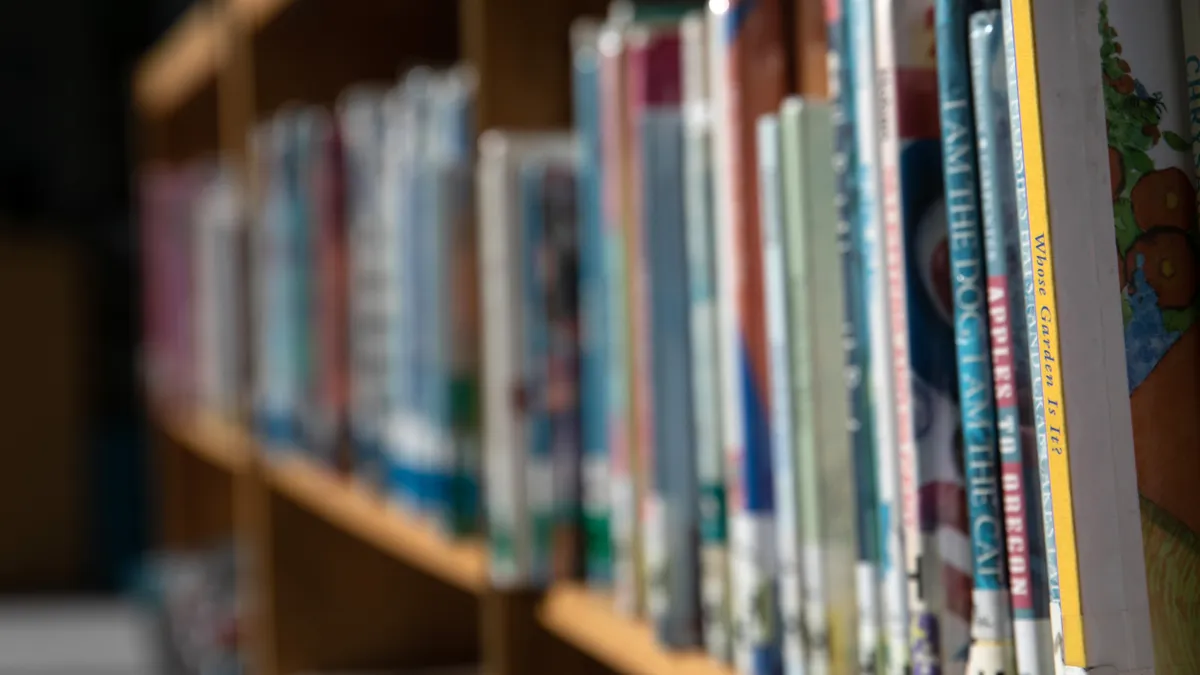 From an angled vantage point, an array of colorful books are shown extending into the distance on a library shelf.