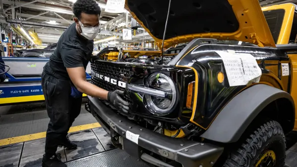 A worker installs the grill on a 2021 Bronco at Ford's Michigan Assembly Plant.