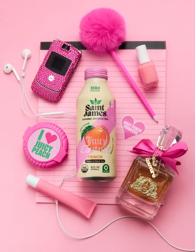 A Saint James Tea bottle is surrounded with various items reminiscent of the 2000s, including a flip phone.
