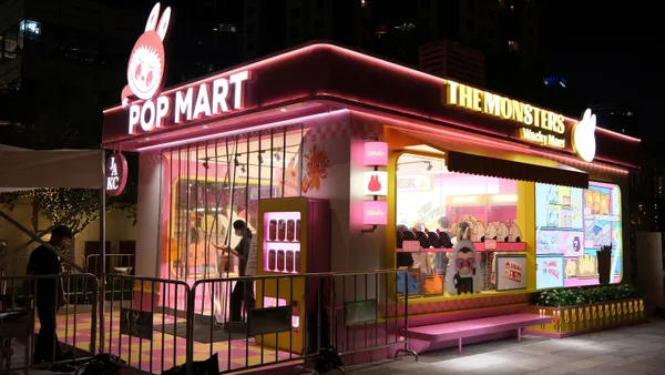 A store with pink neon signs featuring a Labubu toy monster on the front.