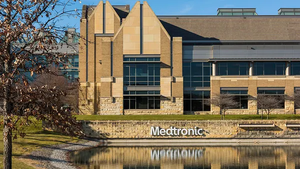 The exterior of Medtronic's Minnesota operational headquarters is shown along with its reflection in a pool of water.