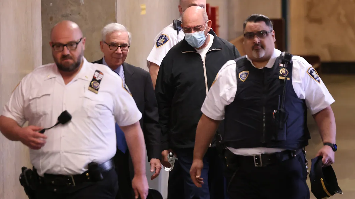 ex-CFO Allen Weisselberg being escorted by law officers following perjury sentencing