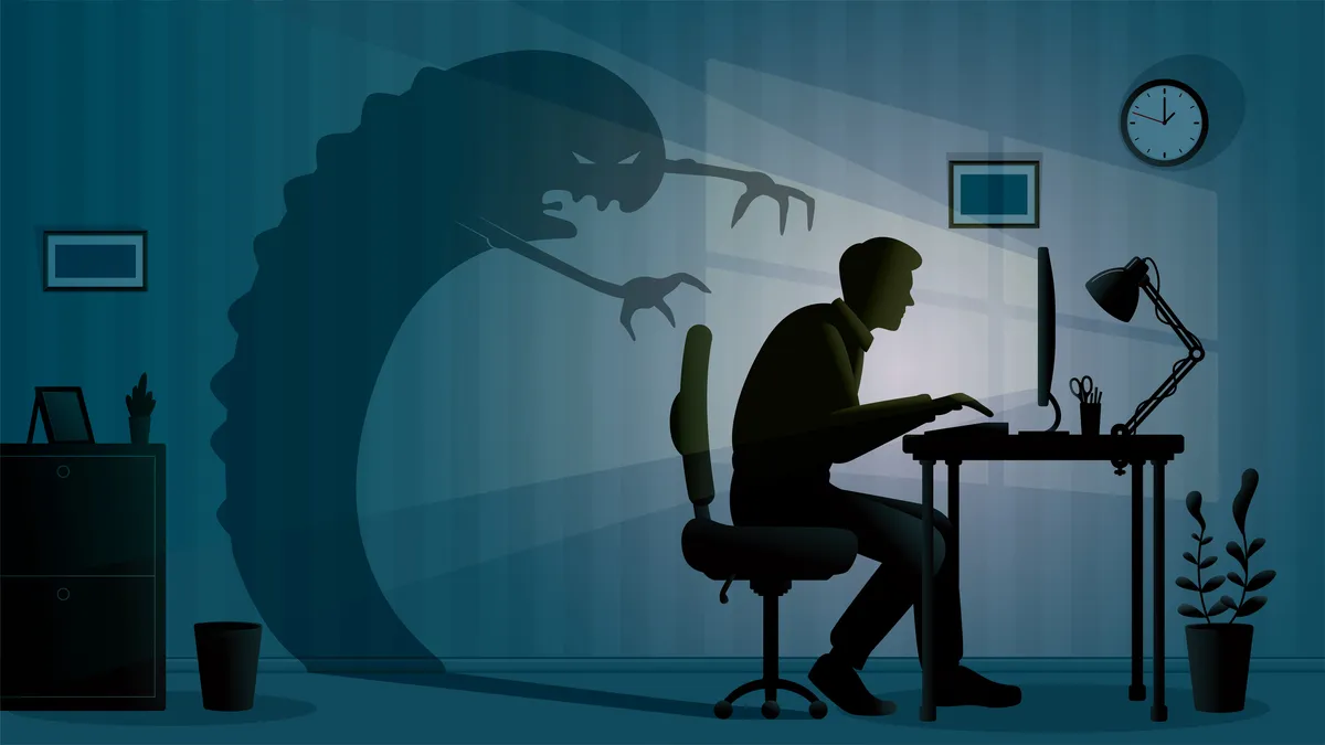 A man at a desk with a shadow monster behind him