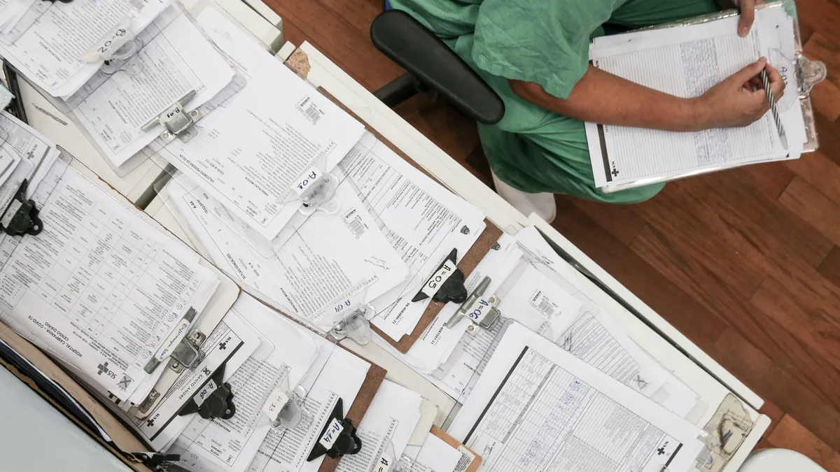 A stack of medical records displayed on a desk.