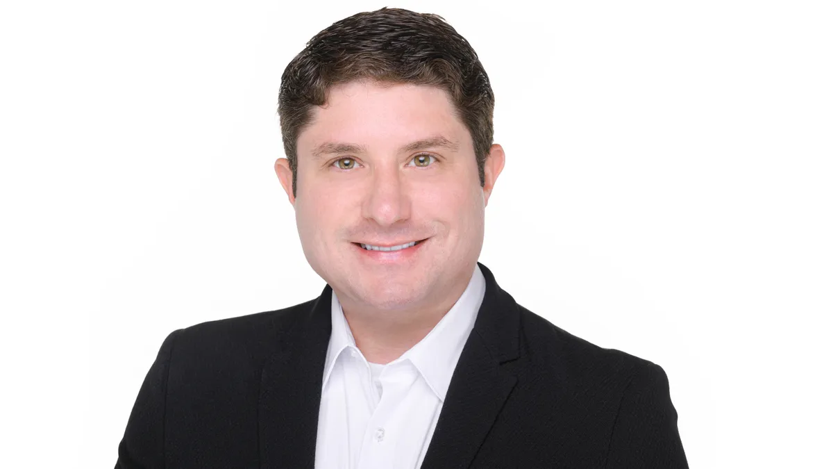 An image of a man wearing a suit in front of a white background.