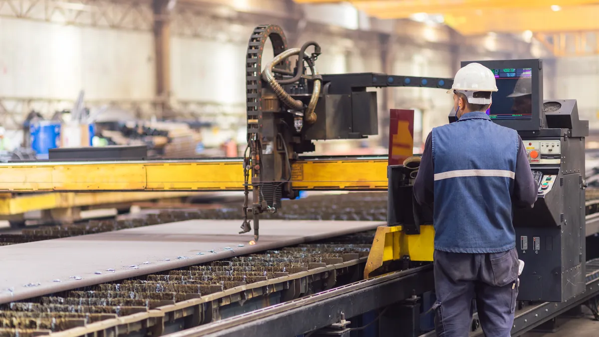 Steel worker on CNC plasma cutter machine