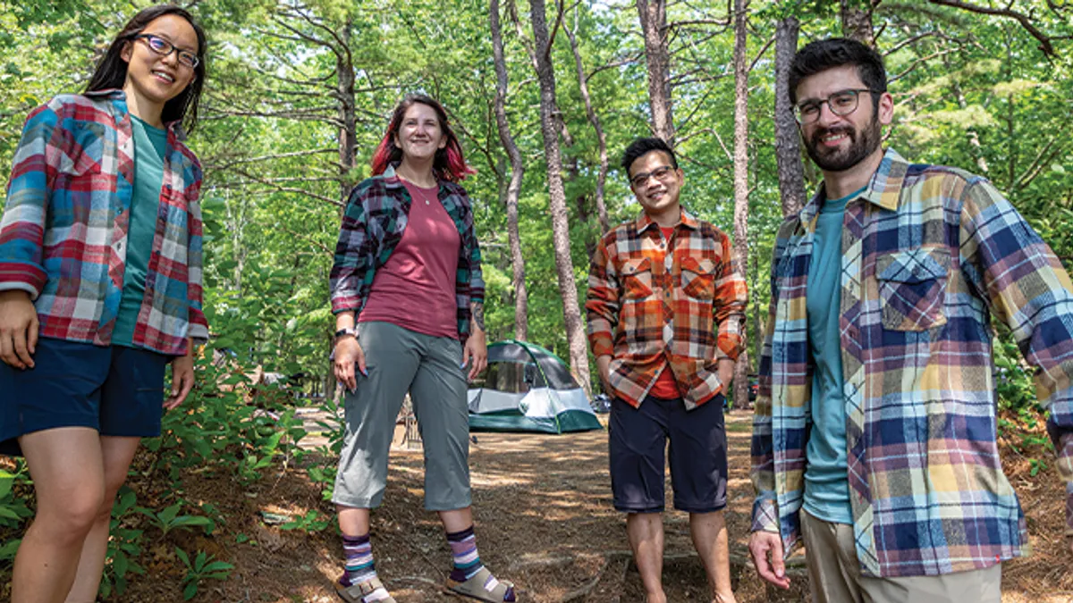 A group of four people out hiking in the woods.