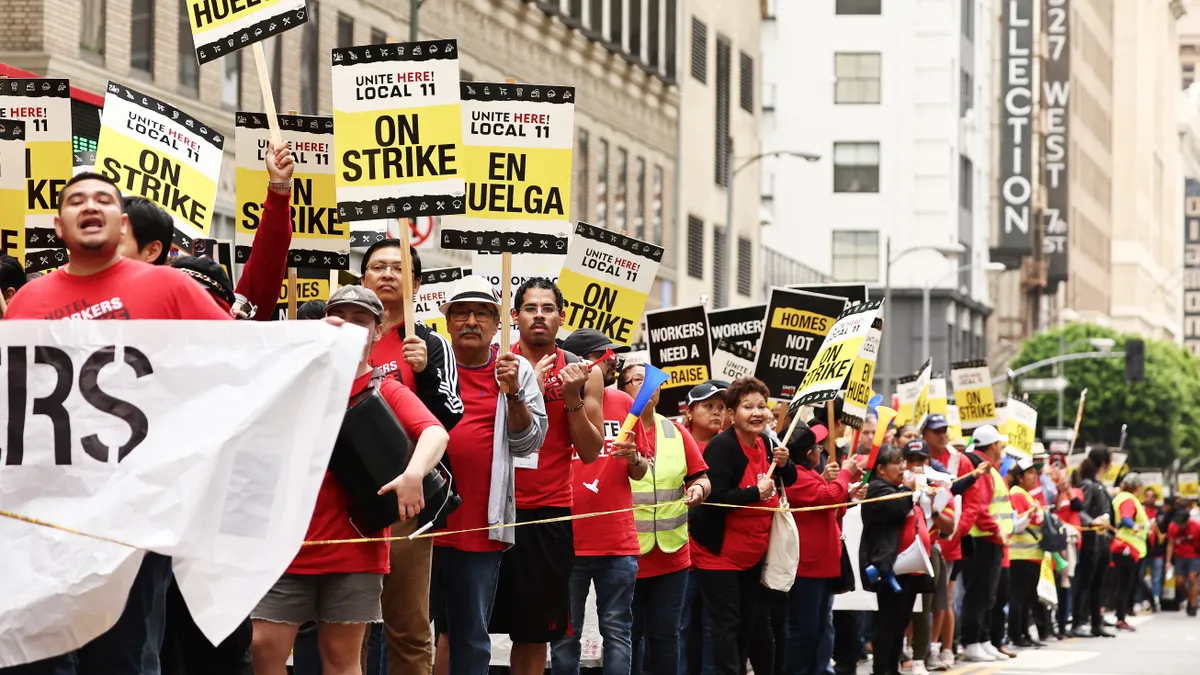 Workers hold picket signs and march.