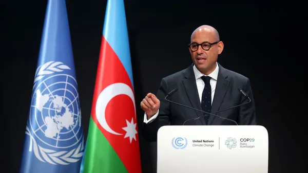 UNFCCC Executive Secretary Simon Stiell delivers a speech in front of a podium.