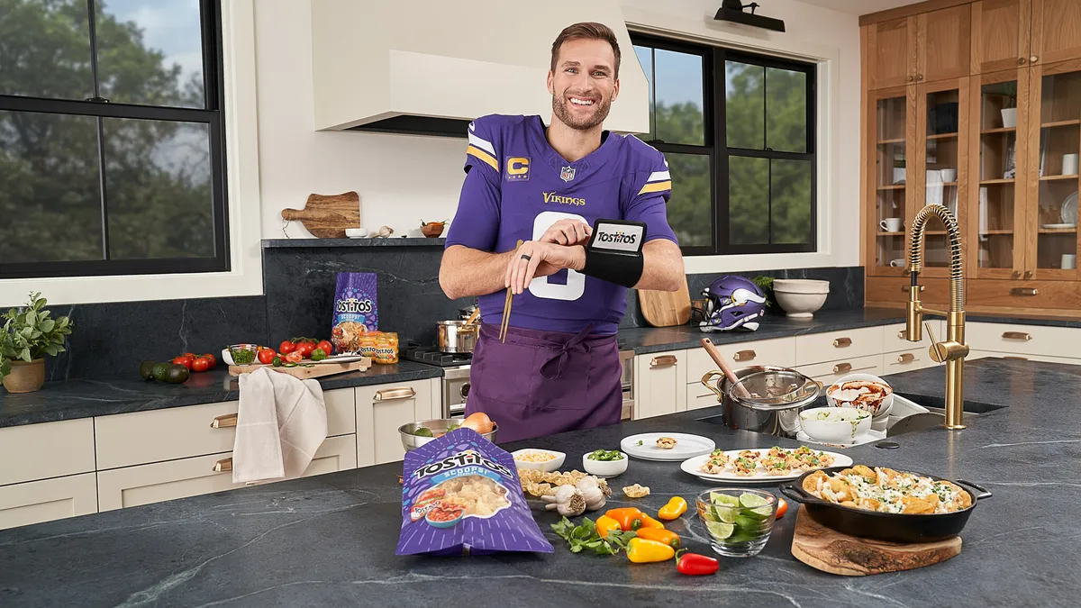 NFL quarterback Kirk Cousins stands in a kitchen in a promotional shoot for brand partner Tostitos