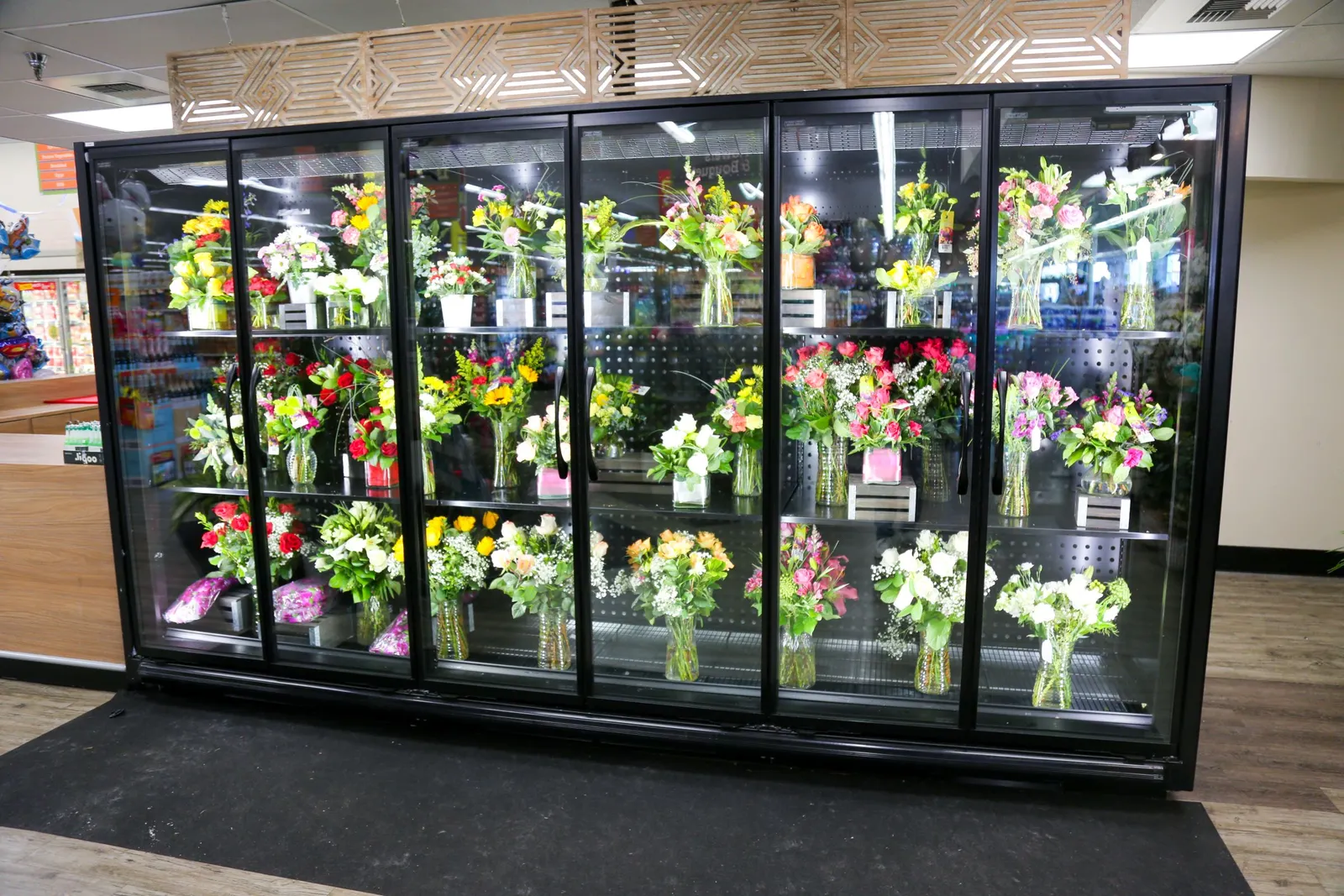 Floral display case inside a grocery store stocked with bouquets
