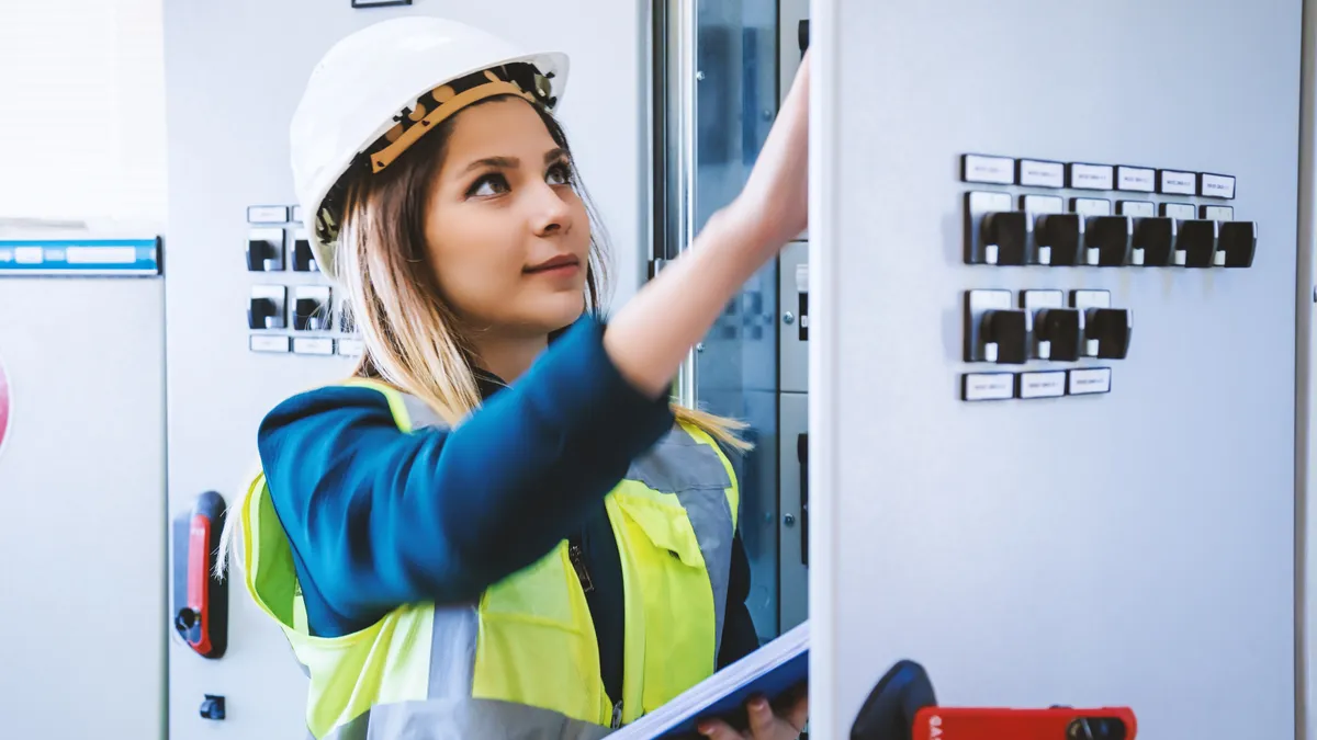 Young woman industrial service engineer wearing white helmet