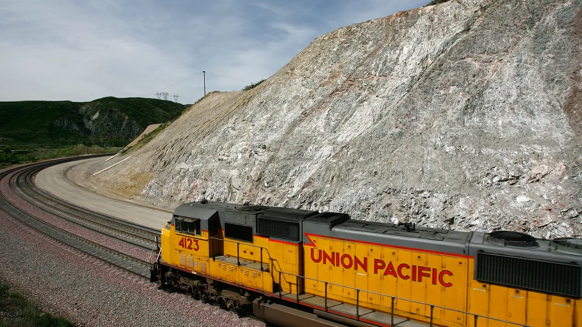 A Union Pacific Railroad train comes around a mountain