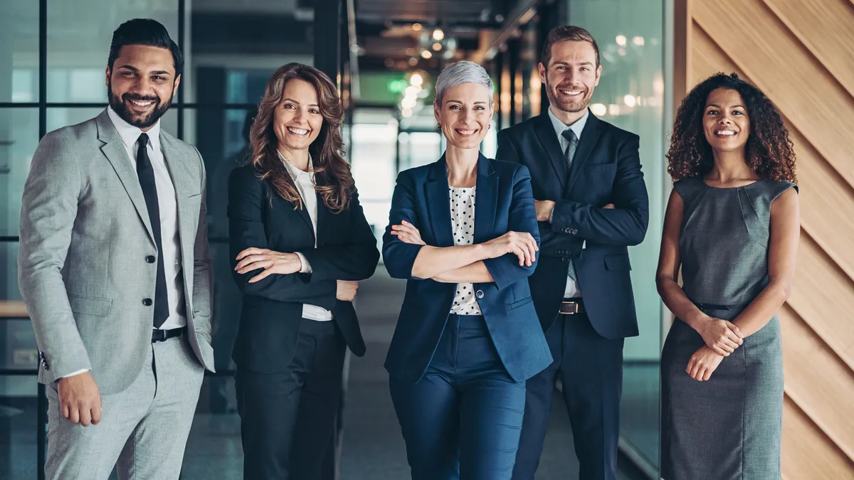 A group of five lawyers standing next to each other in an office