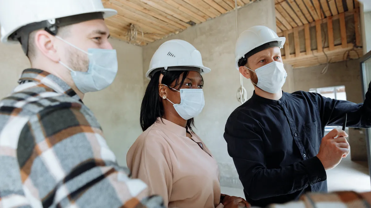 Multiracial, multi-gendered team works in a house