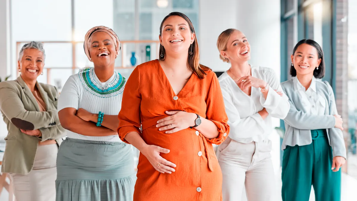 Arms crossed portrait of a pregnant woman with a team for diversity in the workplace.