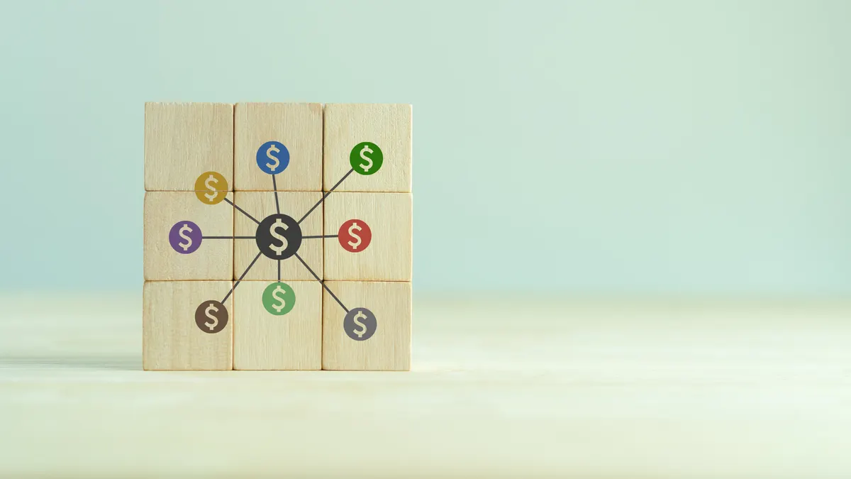 Wooden block put together in a square with dollar signs