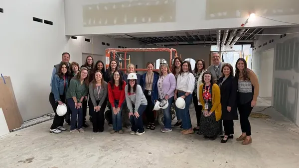 A group of people stand together inside a new building's construction site.