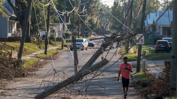 A person walks past downed power lines