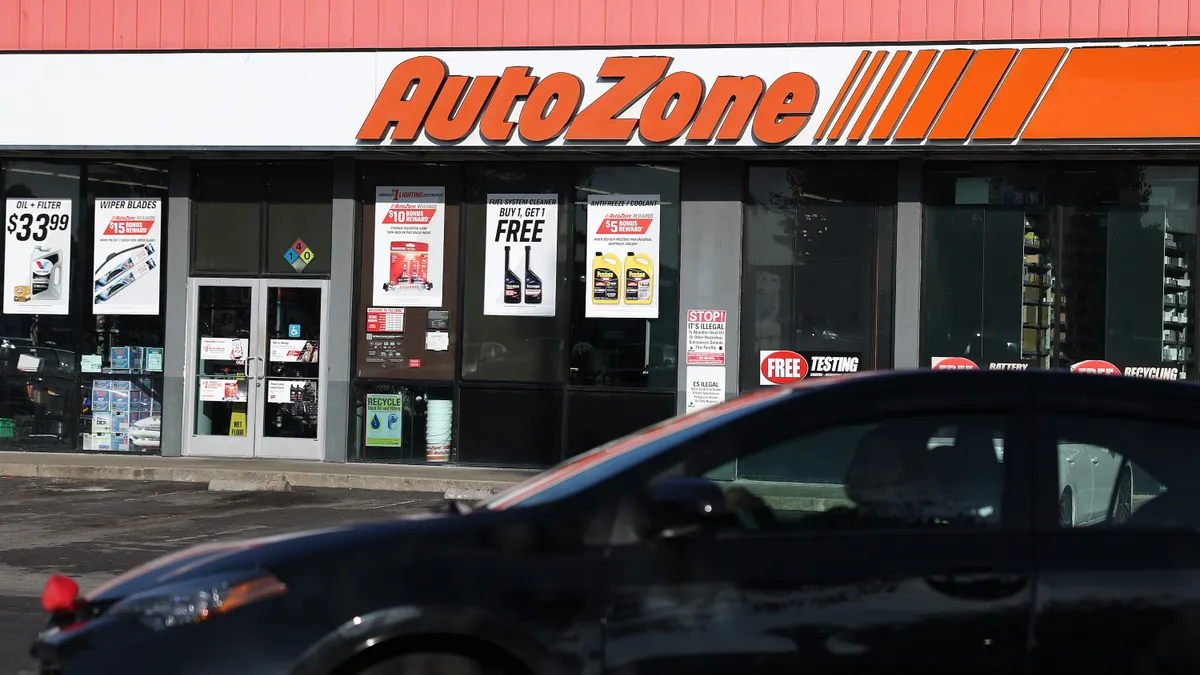 Exterior of an AutoZone retail store, car in foreground