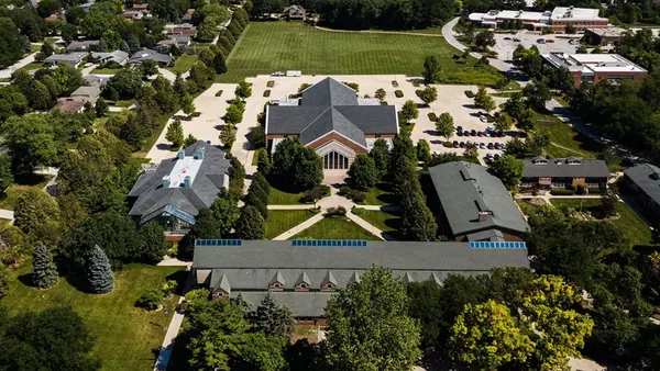 Aerial view of campus, with a group of four large buildings at center.