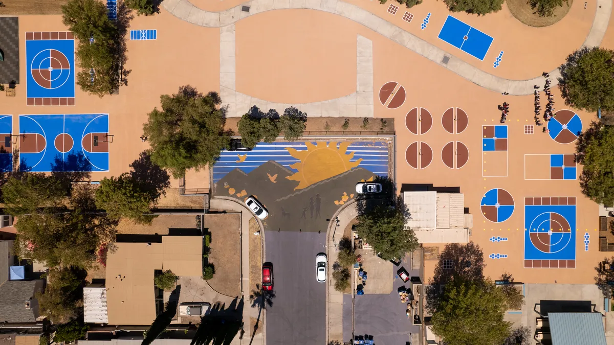 Aerial shot of street with sun mural and sports courts